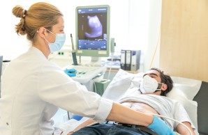 Fachärztin nimmt eine Sonografie beim Patienten vor