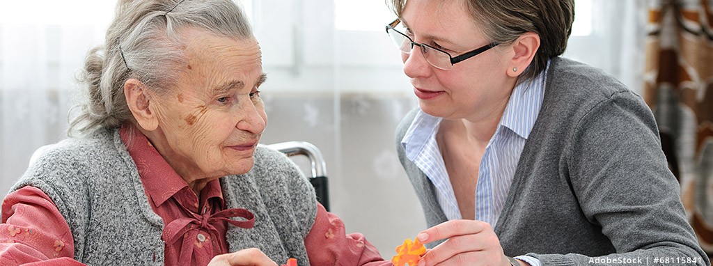 Bildbeispiel für Demenz - eine Pflegerin spricht mit einer älteren Dame