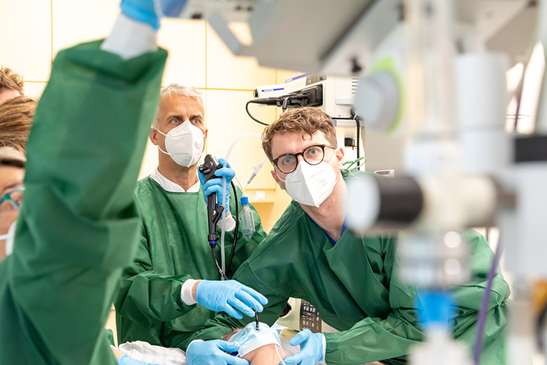 Im OP wird eine Bronchoskopie von zwei Ärzten durchgeführt, die von einem kleinen Team unterstützt werden.